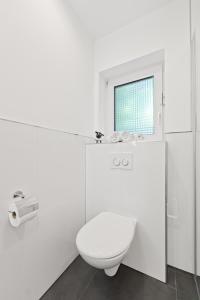 a white bathroom with a toilet and a window at Cozy Cologne Premium Apartment with free parking! NEW! in Cologne