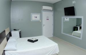 una habitación de hospital con una cama y un espejo en Nidore Motel, en Boa Vista
