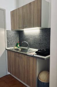 a kitchen with wooden cabinets and a sink at Gennadi Sun Apartments 300m from the beach in Gennadi