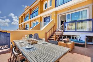Un patio con mesa y sillas y un edificio. en Casa Bita El Cotillo Playa home with swimming pool, en Cotillo
