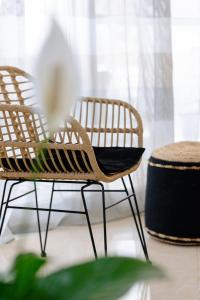a room with two chairs and a flower on a table at La Hacienda cozy home in Pigi