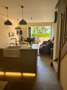 a kitchen with a sink and a living room at Hot tub on the Yorkshire Wolds Oak Cottage in South Cave