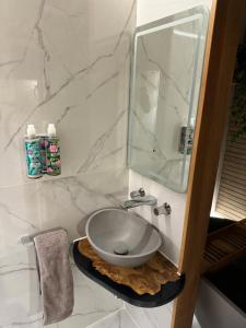 a white marble bathroom with a sink and a mirror at Hot tub on the Yorkshire Wolds Oak Cottage in South Cave