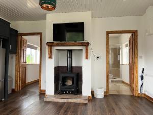 a living room with a fireplace and a tv on a wall at One Bedroom House near Ballinamore in Ballinamore