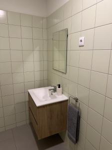 ein Badezimmer mit Waschbecken und Spiegel in der Unterkunft Casa da Joana T2 no Centro Histórico de Angra in Angra do Heroísmo