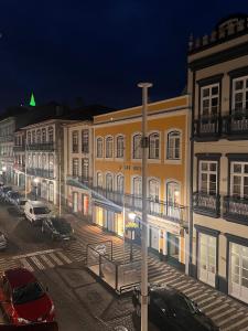 eine Straße bei Nacht mit vor Gebäuden geparkten Autos in der Unterkunft Casa da Joana T2 no Centro Histórico de Angra in Angra do Heroísmo + 22 Fotos