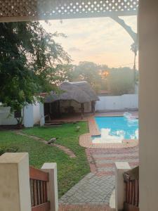 a small house with a swimming pool and a hut at Double Room with Garden View in Pretoria