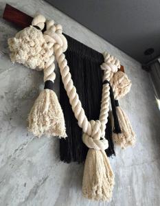 a rope tied to a wall with tassels at "Designer Cave Loft" in Tulum Hotel Zone - Beach Club included in Tulum