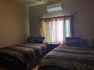 Un dormitorio con dos camas frente a una ventana. en Casa Cupulas, en Puerto Peñasco 8 fotos más