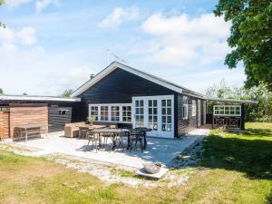 a house with a patio and a table at 4 star holiday home in Grenaa-By Traum in Grenå