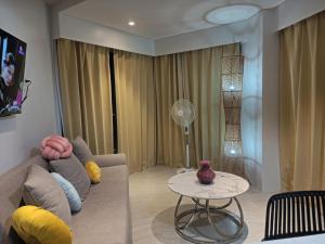 a living room with a couch and a table at Tambuli Beach Ocean view condo in Lapu Lapu City