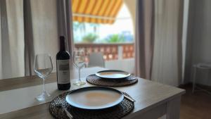 una mesa con dos platos y una botella de vino en Flamingo Palmar, en Palm-mar