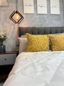 a bedroom with a white bed with yellow pillows at Casa Yon-Pet friendly, Parking gratis, factura, Netflix, wifi alta velocidad in Cuautitlán Izcalli