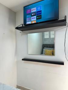 a flat screen tv on a shelf in a room at Casa Yon-Pet friendly, Parking gratis, factura, Netflix, wifi alta velocidad in Cuautitlán Izcalli
