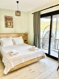 a bedroom with a large bed and a balcony at AKSOY TAŞ EV in Bodrum City