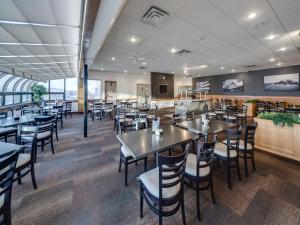 uma sala de jantar com mesas e cadeiras num restaurante em Heritage Inn Hotel & Convention Centre - Pincher Creek em Pincher Creek