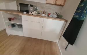 a white kitchen with a sink and a microwave at Monteiro Duplex Terrace - attic in Mercês