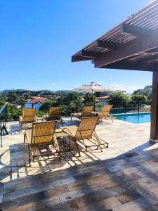 a group of chairs sitting next to a swimming pool at Pousada Búzios Garden in Búzios