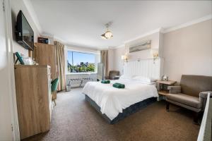 a hotel room with a bed and a chair at Anvershiel House in Portrush