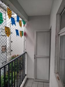 Un balcón con una puerta y una valla con banderas. en Spacious apartment in Campina Grande, en Campina Grande