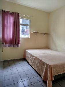 Una pequeña habitación con una cama y una ventana. en Spacious apartment in Campina Grande, en Campina Grande