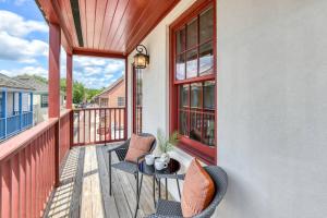 a balcony with two chairs and a table and windows at 61 Spanish St. Unit A in St. Augustine