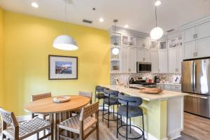 a kitchen with yellow walls and a wooden table and chairs at 61 Spanish St. Unit A in St. Augustine