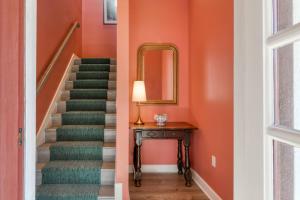 a staircase with a mirror and a table with a lamp at 61 Spanish St. Unit A in St. Augustine