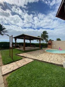 a pavilion next to a swimming pool in a yard at Chalé Beira Mar - Tamandaré in Tamandaré