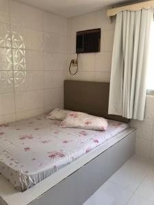 a small bed in a room with a window at Chalé Beira Mar - Tamandaré in Tamandaré