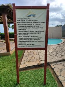 a sign in the grass in front of a pool at Chalé Beira Mar - Tamandaré in Tamandaré