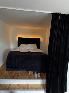 a bed in a room with a black curtain at Semesterlägenhet nära Vättern in Karlsborg