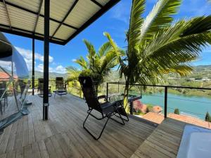 una terrazza con sedia e vista sull'acqua di Glamping Montecarlo Domo Geodesico y Sauna Finlandés Guatapé a Guatapé