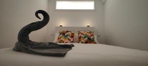 a bedroom with a bed with a swan sculpture on it at Flamingo Palmar in Palm-Mar