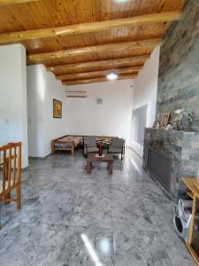 a living room with a stone wall and wooden ceilings at Casa Simón in San Rafael