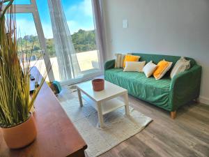 a living room with a green couch and a table at Ericeira Ribamar Sea View Villa in Santo Isidoro