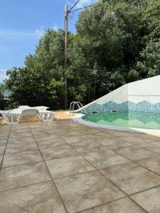 a patio with a table and a swimming pool at Sea and Mountain View - Cozy Pool Flat - Sleeps 6 in Dobrota