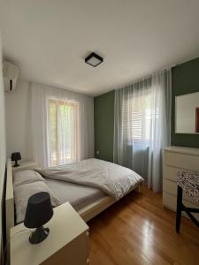 a bedroom with a bed and a window at Sea and Mountain View - Cozy Pool Flat - Sleeps 6 in Dobrota +41 photos