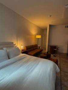 ein Schlafzimmer mit einem großen weißen Bett und einer Couch in der Unterkunft Elegant Suite at Marina-Venice Beach with Pool, Jacuzzi, GYM by Holisticā Retreats in Los Angeles