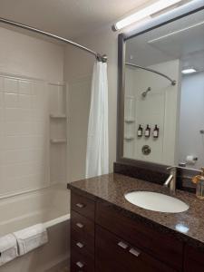 ein Badezimmer mit Waschbecken, Badewanne und Spiegel in der Unterkunft Elegant Suite at Marina-Venice Beach with Pool, Jacuzzi, GYM by Holisticā Retreats in Los Angeles