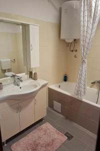 a bathroom with a sink and a tub and a mirror at Apartments with swimming pool Poljica, Zadar - 13838 in Vrsi