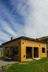 a small wooden house with a large window at Refugio del Pescador in Esquel