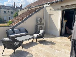 a patio with a couch and chairs and a table at Maison rénovée en Berry : terrasse, jardin privé, proche Châteauroux et nature - FR-1-591-164 in Saint-Maur