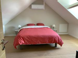 a bedroom with a red bed in a attic at Maison rénovée en Berry : terrasse, jardin privé, proche Châteauroux et nature - FR-1-591-164 in Saint-Maur