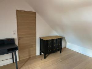 a bedroom with a black dresser and a door at Maison rénovée en Berry : terrasse, jardin privé, proche Châteauroux et nature - FR-1-591-164 in Saint-Maur +4 photos