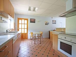 una grande cucina con tavolo e sedie di Gîte familial aux Vosges avec jeux pour enfants, à proximité de la nature et activités sportives - FR-1-589-111 a Le Ménil