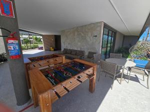 un grande tavolo da calcio balilla in legno in un soggiorno di Beach Class Summer na Praia do Cupe - Locar House a Porto De Galinhas