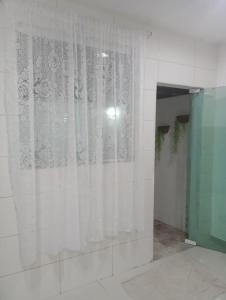 ein Zimmer mit weißen Vorhängen an einer Wand in der Unterkunft Casa para vc curtir 2 in Cabo Frio