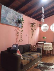 a living room with a couch and a pink wall at Zen Maharani Guesthouse - Qt nº 5 in Bauru