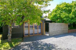 a house with a tree in front of it at The French Cottage Great Wifi Private in Taupo